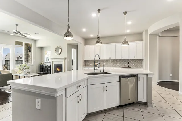 a kitchen with kitchen island granite countertop a sink a stove and cabinets