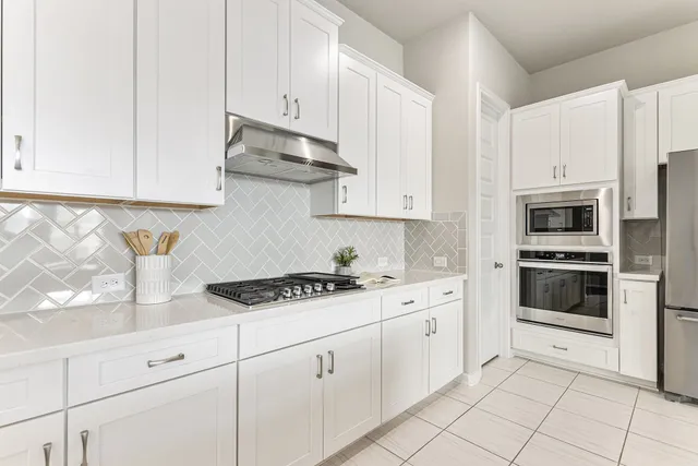 a kitchen with granite countertop white cabinets and white appliances