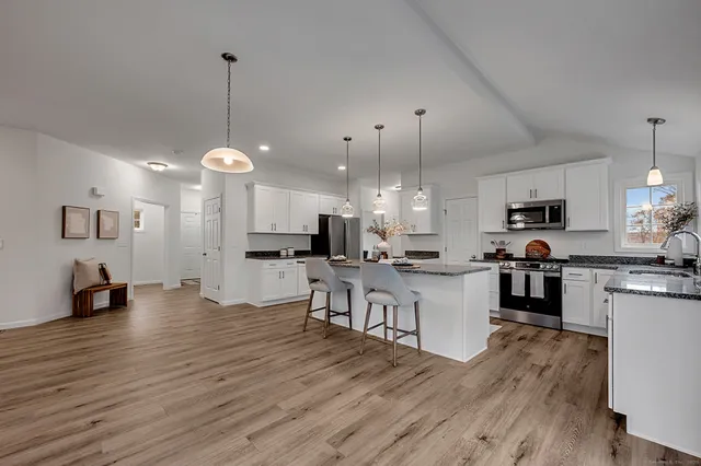 a kitchen with stainless steel appliances kitchen island a refrigerator a stove a sink and a oven