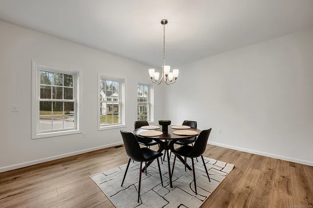 a view of a dining room with furniture a chandelier and wooden floor
