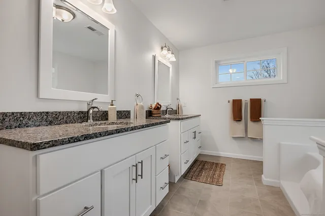 a bathroom with a double vanity sink and mirror