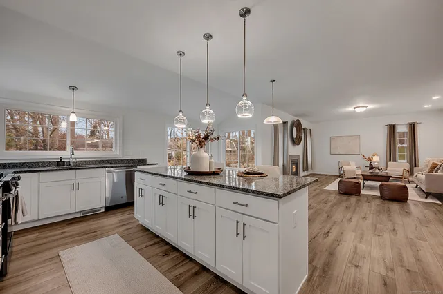 a kitchen with kitchen island granite countertop a sink counter top space and living room view
