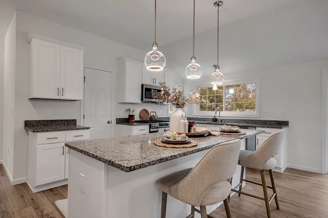 a kitchen with a counter space cabinets and wooden floor
