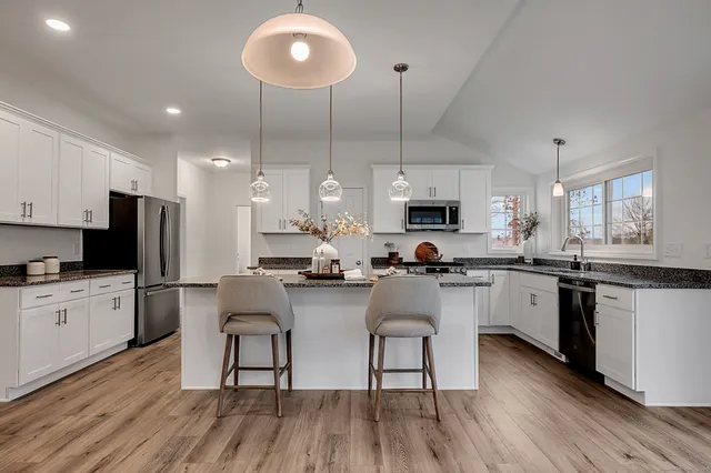 a kitchen with a sink cabinets and wooden floor