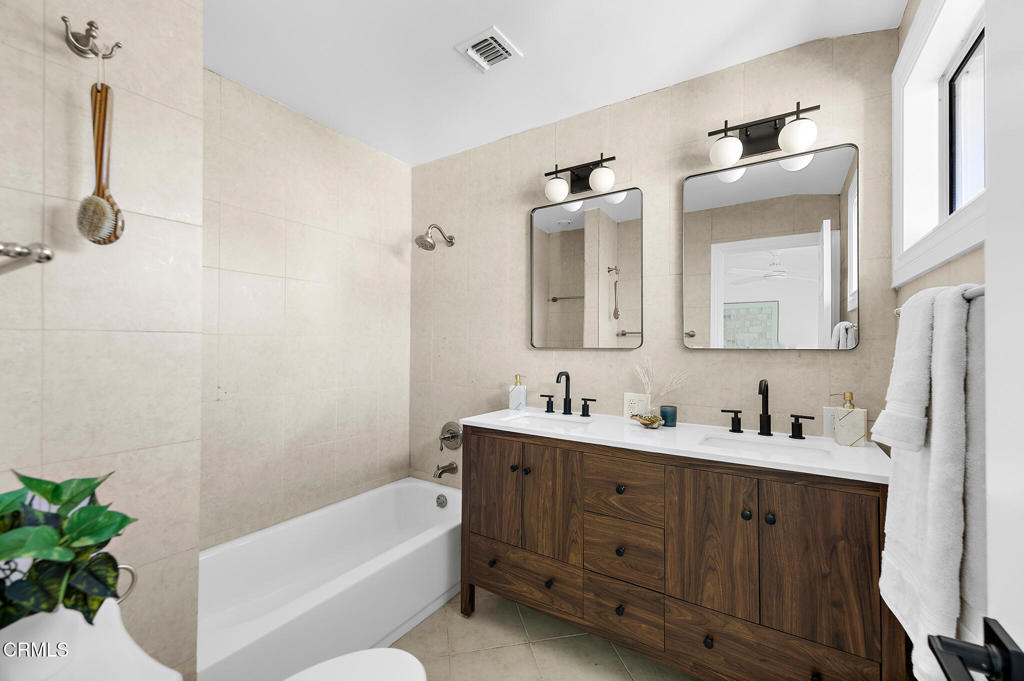 1010 Pepperhill Road Pasadena, CA 91107 - Photo 21 of 35 a bathroom with a double vanity sink a mirror a bathtub and shower