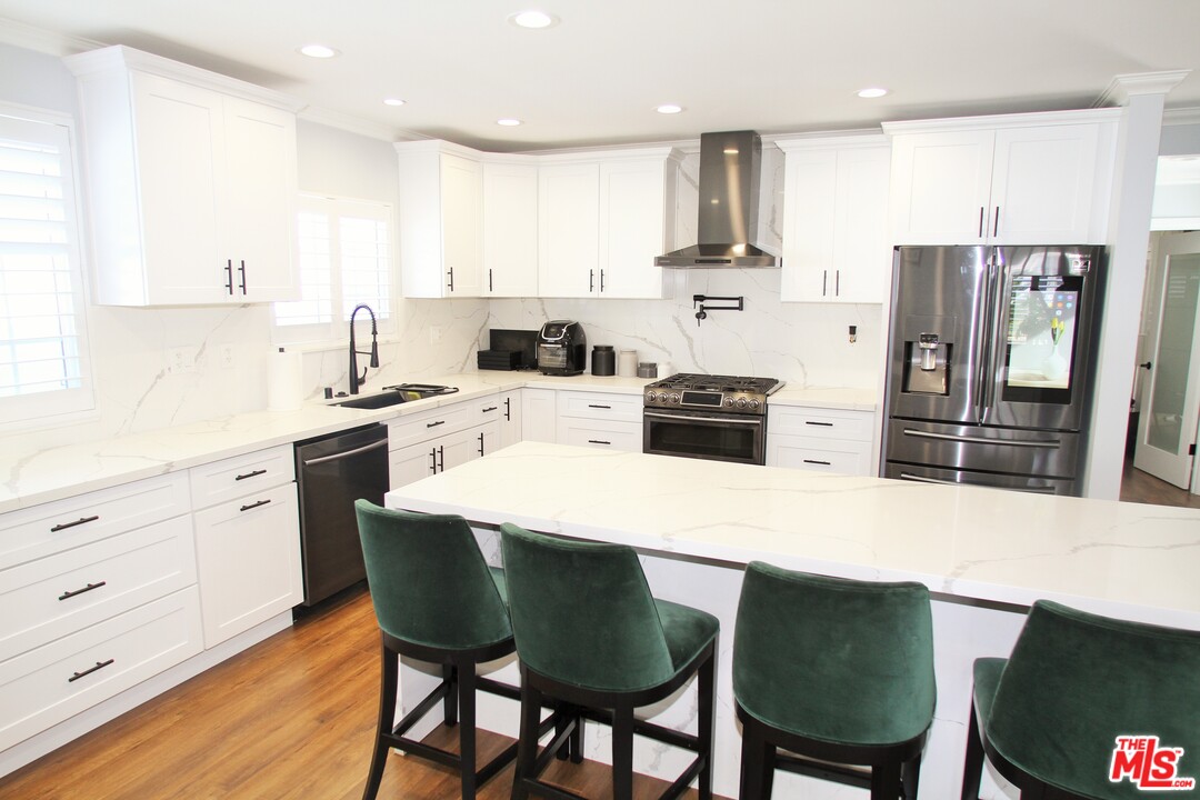 1712 West Poplar Street Compton, CA 90220 - Photo 11 of 41 a kitchen with refrigerator cabinets dining table and chairs
