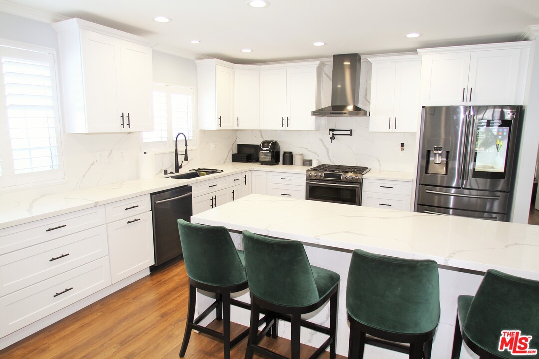 1712 West Poplar Street Compton, CA 90220 - Photo 12 of 41 a kitchen with stainless steel appliances kitchen island granite countertop a table chairs microwave and cabinets