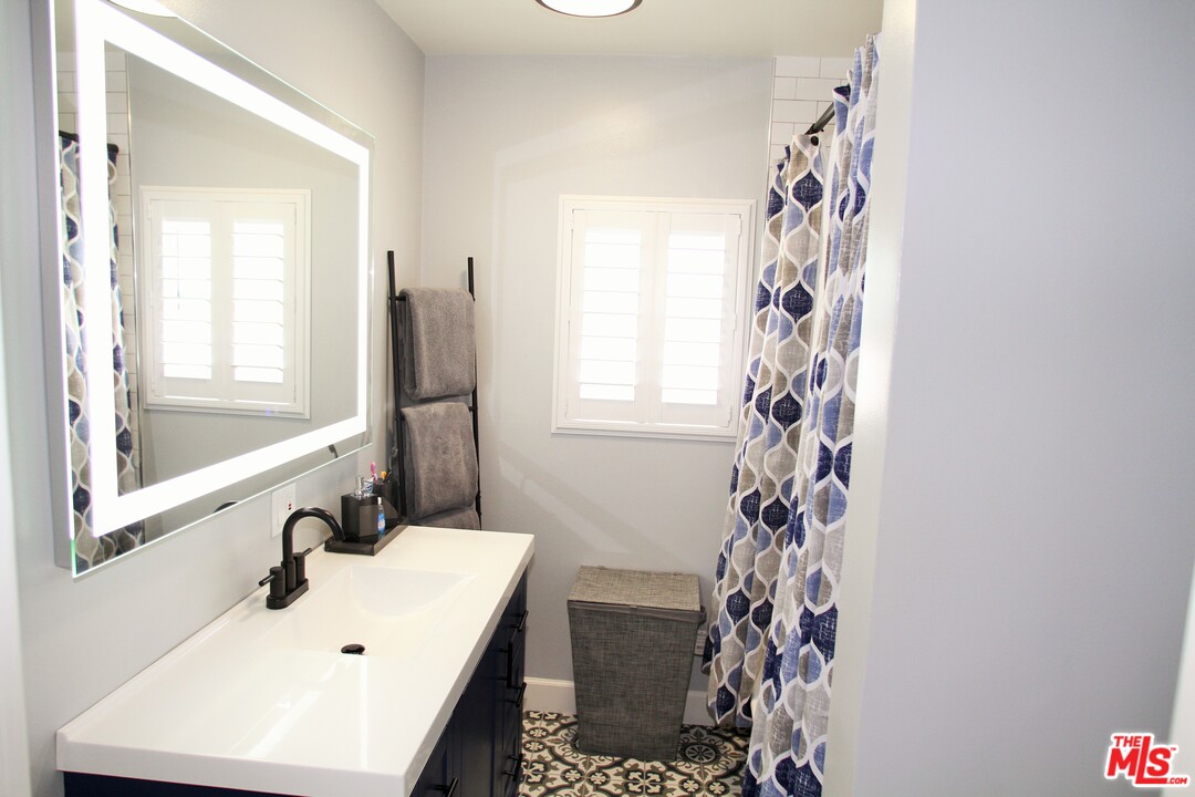 1712 West Poplar Street Compton, CA 90220 - Photo 17 of 41 a bathroom with a sink a mirror and a shower
