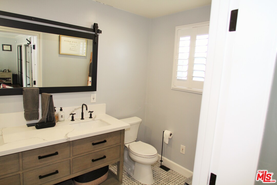 1712 West Poplar Street Compton, CA 90220 - Photo 24 of 41 a bathroom with a toilet sink and mirror