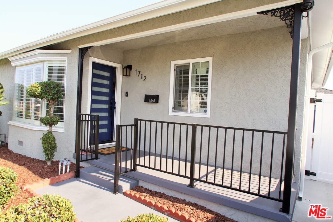 1712 West Poplar Street Compton, CA 90220 - Photo 39 of 41 a view of a balcony with a potted plants and wooden fence