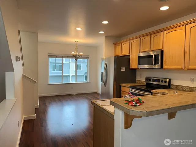 a kitchen with stainless steel appliances granite countertop a stove a sink and a microwave