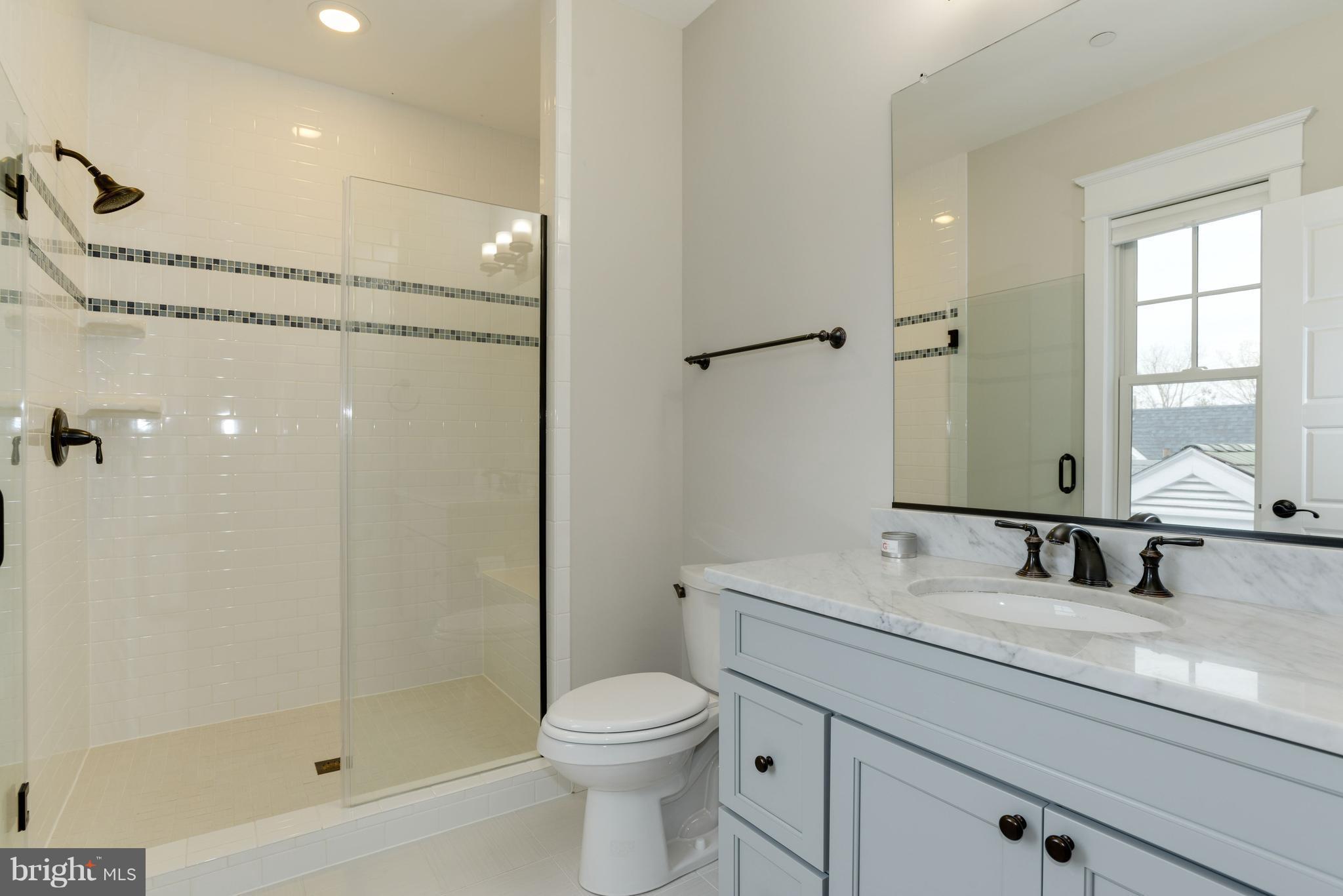 5836 MacArthur Boulevard Northwest Washington, DC 20016 - Photo 20 of 29 a bathroom with a granite countertop sink a toilet and shower
