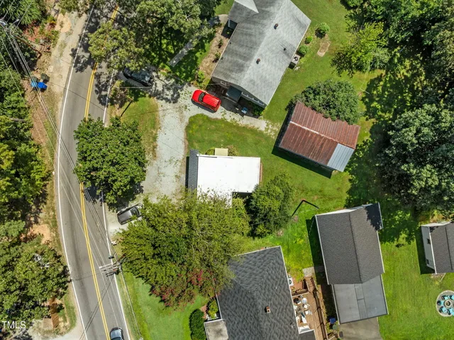 an aerial view of residential houses with outdoor space and trees