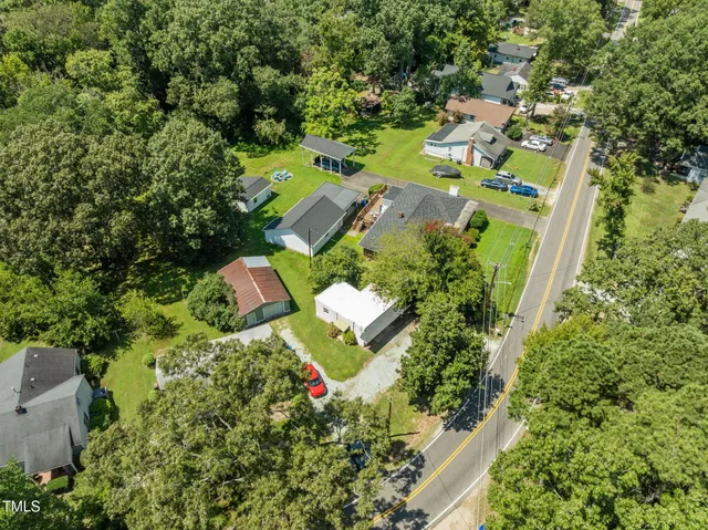 an aerial view of residential houses with outdoor space and trees