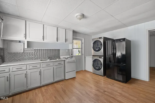 a view of a kitchen with fridge and wooden floor