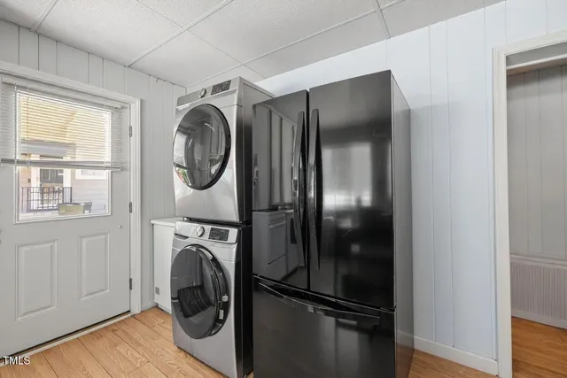 a utility room with wooden floor washer and dryer