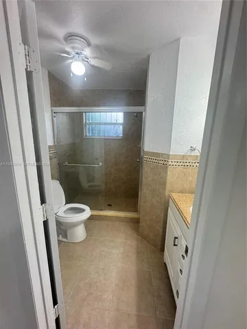 a bathroom with a sink a toilet a mirror and a shower
