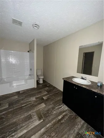 a living room with hard wood floors and a sink
