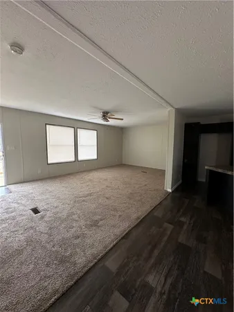 a view of a big room with wooden floor and windows