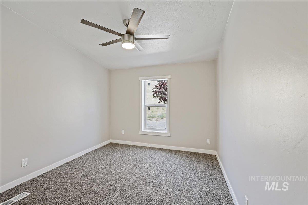 840 Highway 95 Weiser, ID 83672 - Photo 16 of 33 Empty room featuring carpet, a ceiling fan, and a textured ceiling