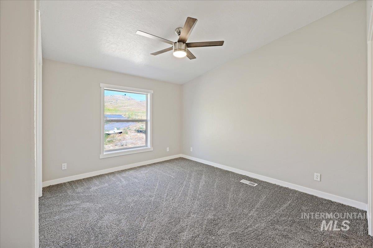 840 Highway 95 Weiser, ID 83672 - Photo 20 of 33 Carpeted empty room featuring a textured ceiling and a ceiling fan