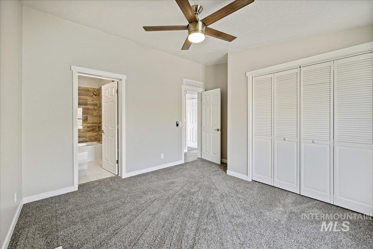 840 Highway 95 Weiser, ID 83672 - Photo 21 of 33 Unfurnished bedroom with a closet, carpet floors, ceiling fan, and ensuite bath