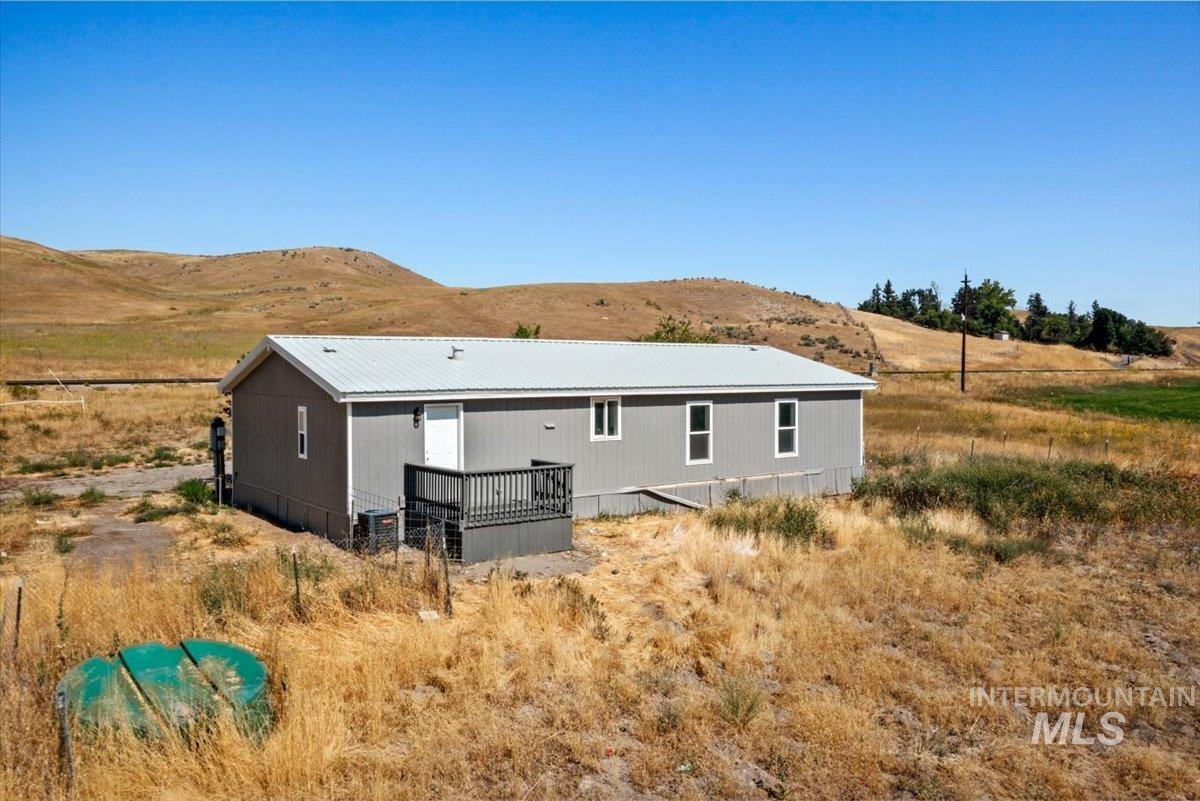 840 Highway 95 Weiser, ID 83672 - Photo 4 of 33 Rear view of property with a deck with mountain view, a metal roof, and a view of rural / pastoral area