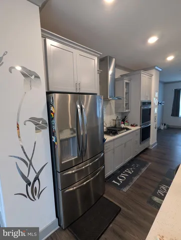 a kitchen with stainless steel appliances granite countertop a refrigerator and a stove top oven