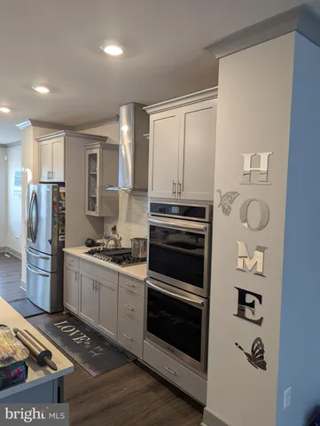 a kitchen with stainless steel appliances a stove a refrigerator and a sink