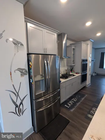 a kitchen with stainless steel appliances granite countertop a refrigerator and a stove top oven