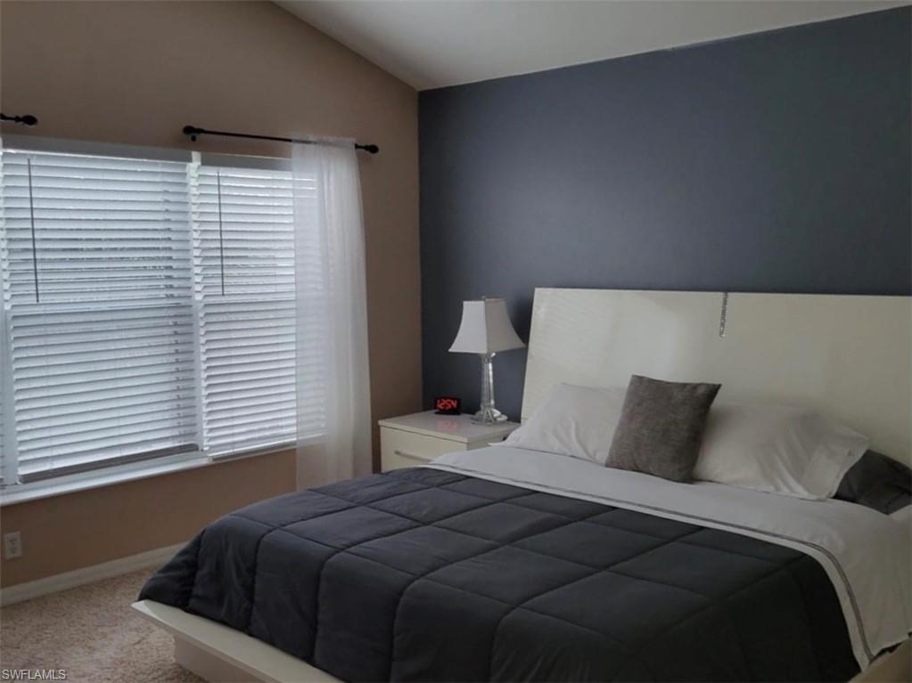 993 Hampton Circle, Unit 122 Naples, FL 34105 - Photo 11 of 26 a bedroom with a large bed and a large window