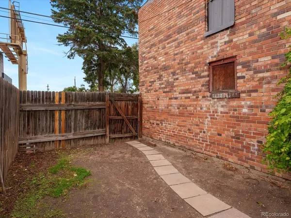 a view of a backyard with wooden fence and a bench