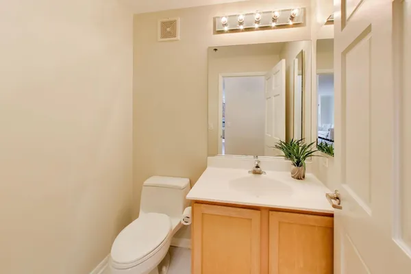 a bathroom with a sink a toilet and mirror