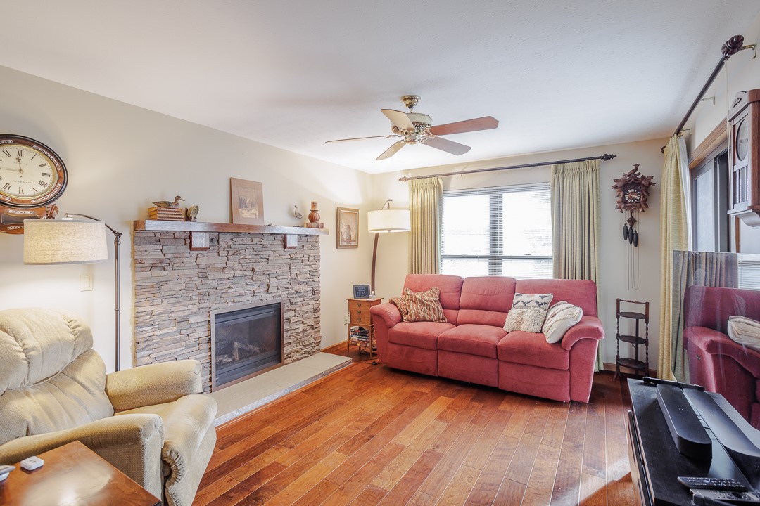 540 Basil Street Springboro, OH 45066 - Photo 11 of 32 This living room features a cozy stone fireplace, rich hardwood flooring, and ample natural light.