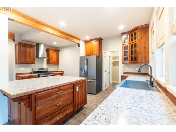a kitchen with stainless steel appliances granite countertop a refrigerator a stove and a sink with large countertops