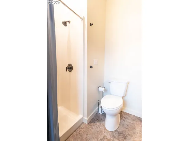a bathroom with a toilet and a shower