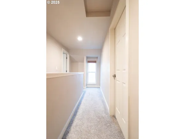 a view of a hallway with white walls plants and kitchen