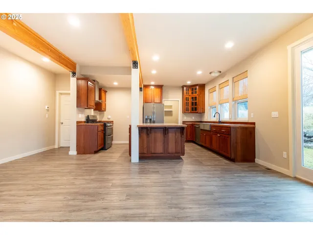 a living room with stainless steel appliances kitchen island granite countertop wooden floors and view living room