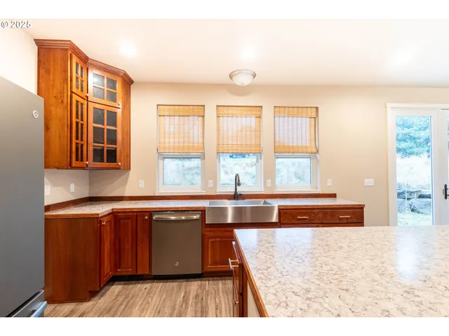 a kitchen with stainless steel appliances granite countertop a sink and wooden cabinets