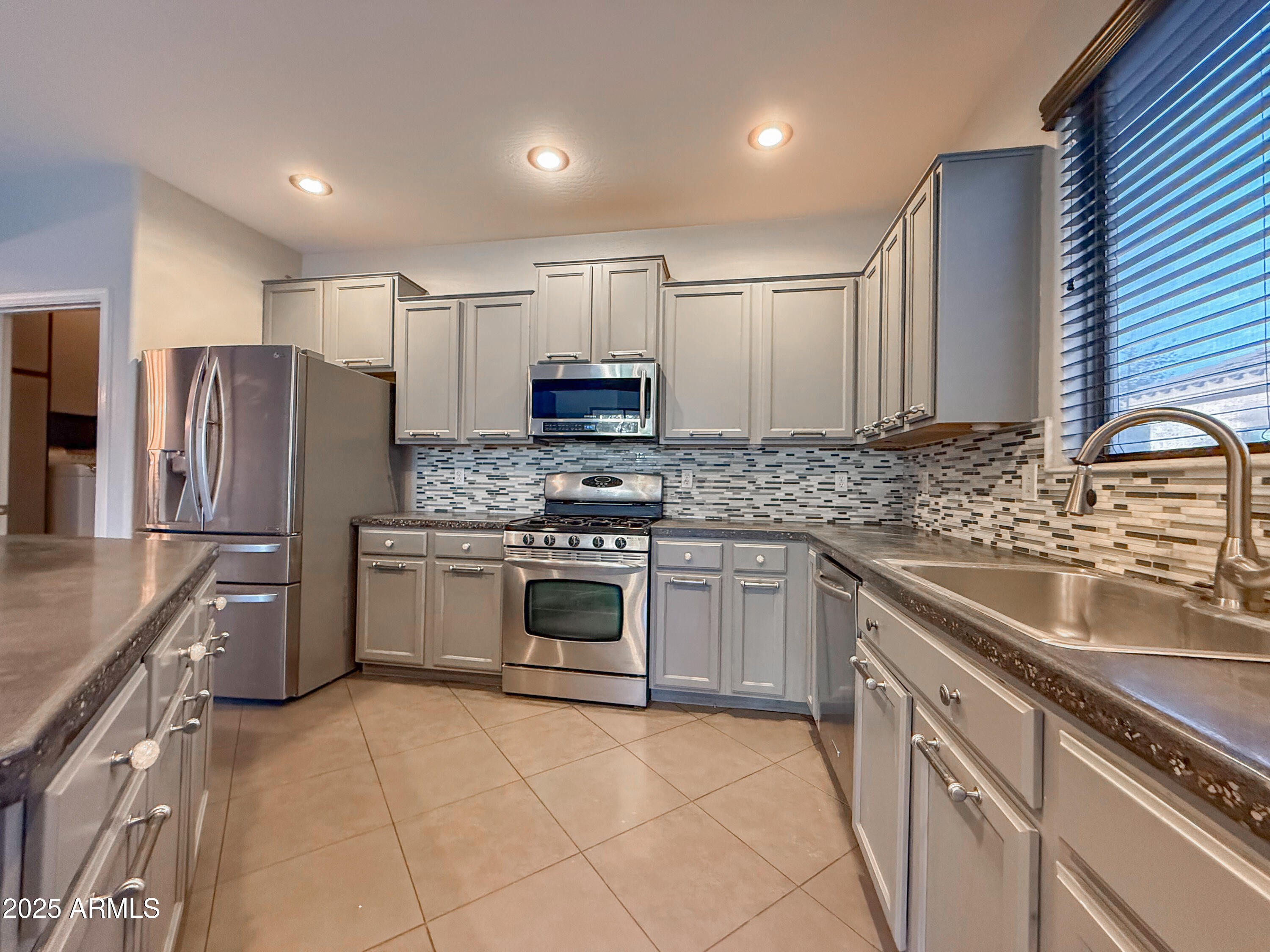 19716 East Thornton Road Queen Creek, AZ 85142 - Photo 21 of 62 a kitchen with stainless steel appliances granite countertop a sink stove and refrigerator