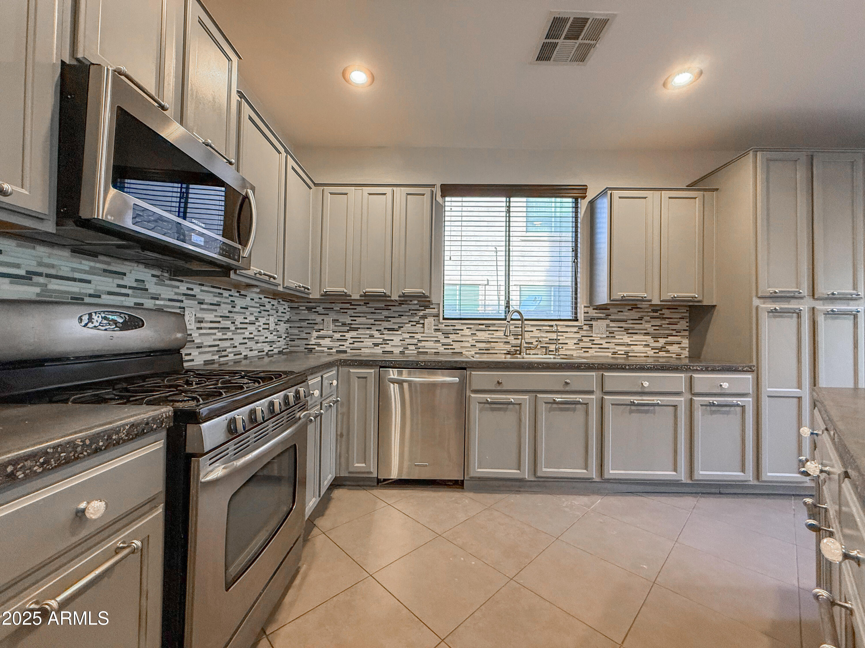 19716 East Thornton Road Queen Creek, AZ 85142 - Photo 22 of 62 a kitchen with stainless steel appliances granite countertop a stove microwave and sink