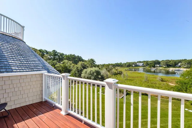 a balcony with wooden floor and lake view