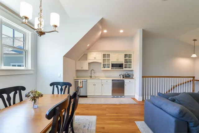 a kitchen with furniture wooden floor and a chandelier