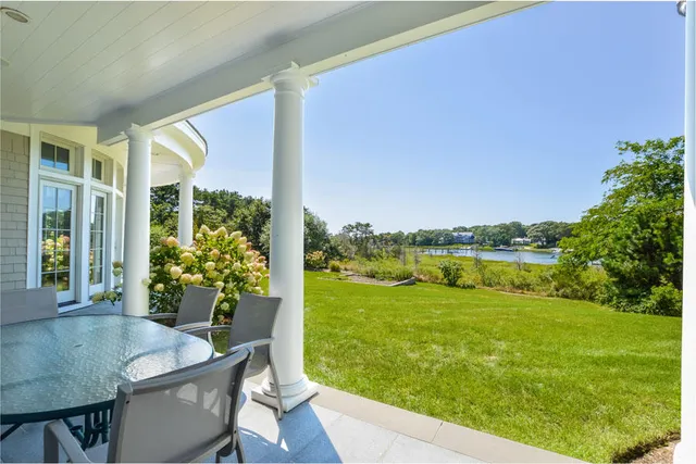 a view of a chairs and table in patio with a garden