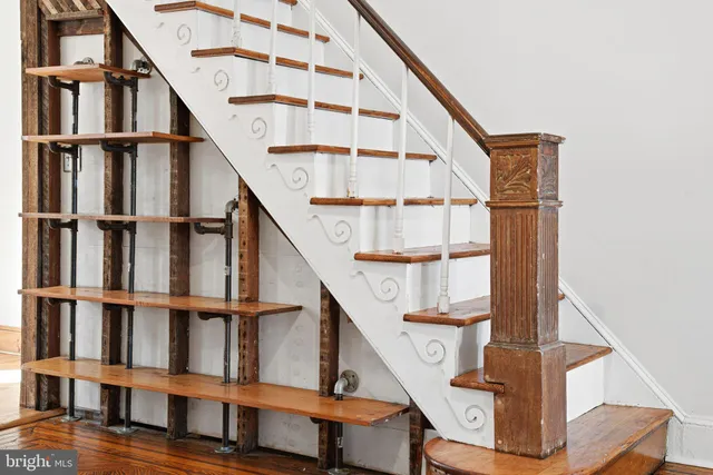 a view of staircase with wooden floor and white walls