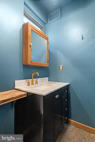 a bathroom with a sink vanity and a mirror
