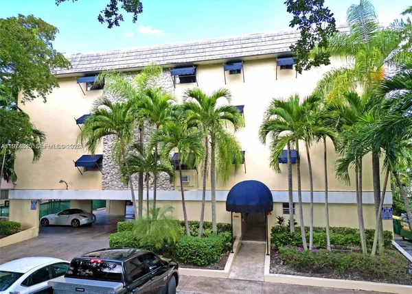 a front view of a house with a yard and potted plants