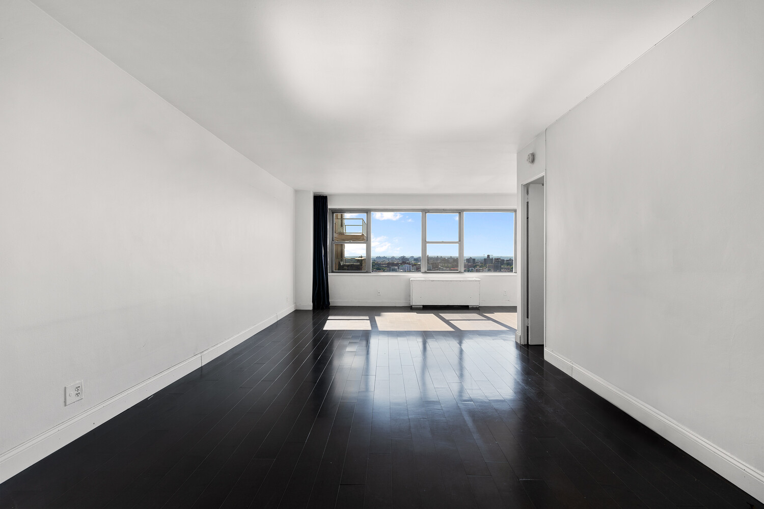 1020 Grand Concourse, Unit 20B Bronx, NY 10451 - Photo 4 of 10 an empty room with wooden floor and windows