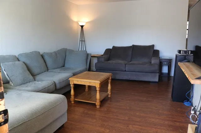 a living room with furniture a lamp and a flat screen tv