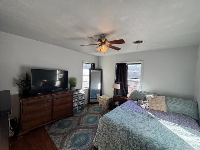 a bedroom with a bed window and a flat screen tv